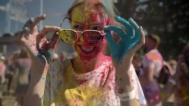 Genç kız renkli toz güneş gözlüğü yaz aylarında gündüz holi festival giyiyor mutlu renk kavramı