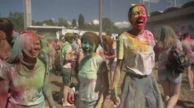 Üç genç çok etnik gruptan oluşan kız atlama ve renkli toz ile holi festival gündüz yaz, dostluk kavramı, renk kavramı dans