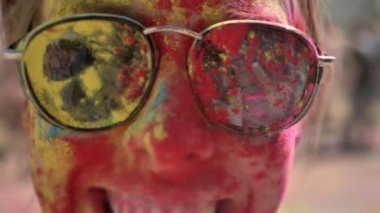 Mutlu kız güneş gözlüğü ile renkli toz çehresini holi festival gündüz yaz, renk kavramı, duygusal kavramı gülümsüyor