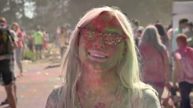 Bununla birlikte güneş gözlüklü genç güzel sarışın kız holi Festivali renkli toz ile gündüz yaz, renk kavramı atılır