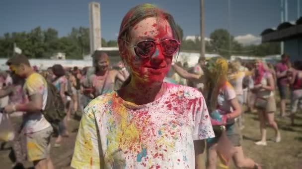 Giovane ragazza felice nei colori viene gettato con polvere colorata sul festival holi di giorno in estate, ridendo, concetto di colore — Video Stock