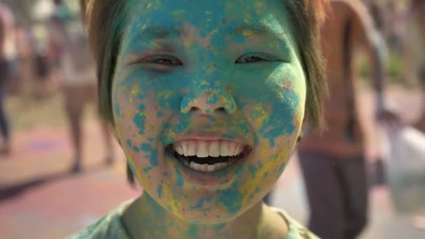 Молодая счастливая девушка улыбается пудрой на празднике Холи летом, цветовая концепция, эмоциональная концепция — стоковое видео