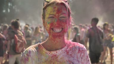 Genç mutlu kız renkli toz holi festival yaz aylarında gündüz izlerken kamera, renk kavramı, duygusal kavramı dans ediyor