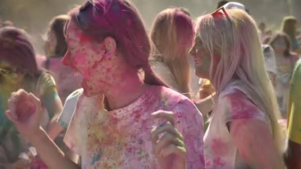Tre unga glada multietniska flickvänner dansar på holi festivalen i dagtid på sommaren, vänskap koncept, holiday koncept — Stockvideo