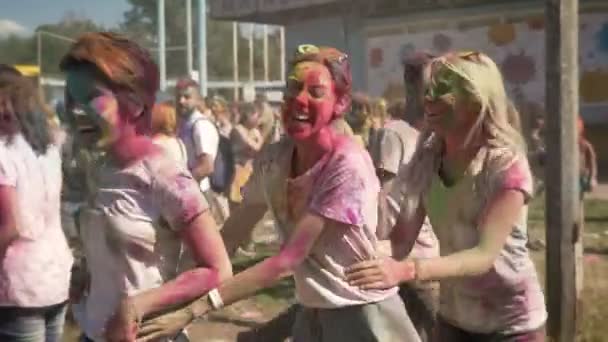 Три молодых счастливых многоэтнических девушки делают конга линии на Холи фестиваля в дневное время в летнее время, концепция дружбы, праздник концепции — стоковое видео