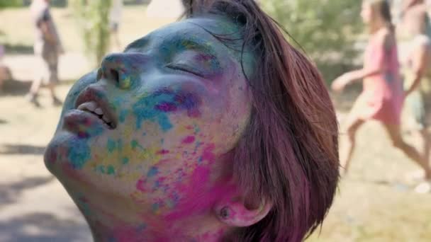 Молодая счастливая азиатка разрывается под дождем на фестивале в Холи в дневное время летом, цветовая концепция, эмоциональная концепция — стоковое видео