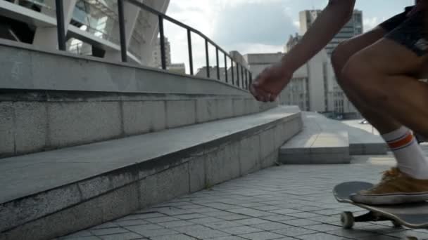 Skateboardista dělá trik na skateboardu na schodech a posadil se na schodiště v moderním městě — Stock video