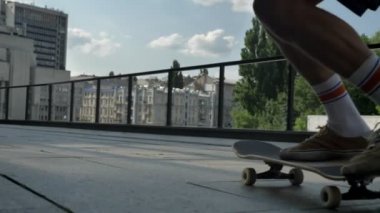 Gündüz yaz, spor kavramı, kentsel kavramı, arkadan görünüm kaykay yapıyor genç adam kaykaycı bacakları hüner