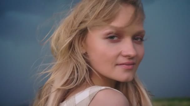 Молода красива дівчина мрійник дивиться на камеру з дощовим небом на фоні, концепція свободи, концепція погоди — стокове відео