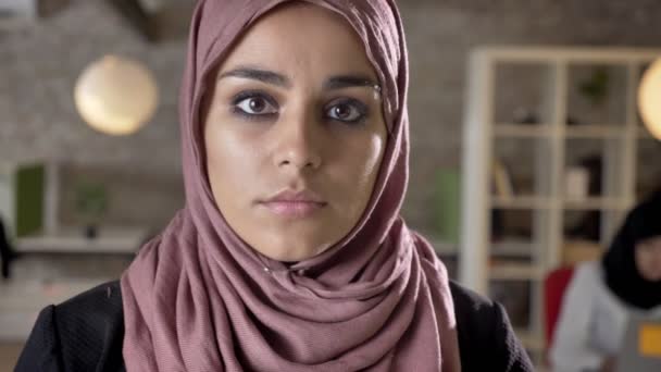 Portrait of young muslim women in hijab looking down and in camera, concerned and serious, people working in modern office — Stok Video