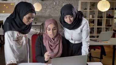 İş planı tartışmak ve laptop modern ofis projesinde söz, işaret hijab genç Müslüman kadın ekibi