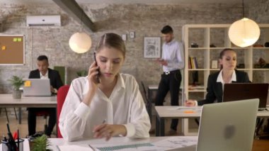 Genç ciddi işkadını kağıtları izlerken ofis, telefonda konuşuyor, insanlar ağ teknolojileri, çalışma kavramı, iş kavramı, iletişim kavramı ile