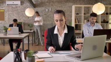 Genç ciddi işkadını laptop ve Office Grafik izlerken, insanların ağ teknolojileri, çalışma kavramı, iş kavramı, iletişim kavramı ile