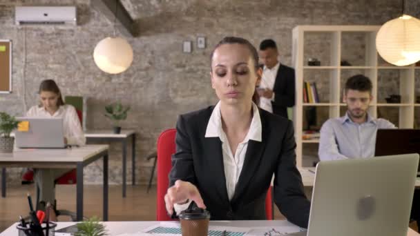 Young beautiful business woman is typing on laptop in office, drinking coffee, people are networking with technologies, working concept, business concept, communication concept — Stock Video