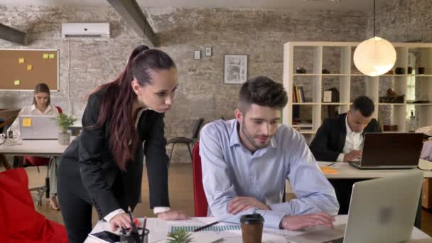 Twee jonge collega's bespreken details over laptop in kantoor, netwerken met technologieën, werk concept, bedrijfsconcept communicatieconcept — Stockvideo