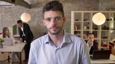 Genç ciddi iş adamı izleyen kamera ofis, arkadaşları ağ teknolojileri, çalışma kavramı, iş kavramı, iletişim kavramı, arka plan bulanık