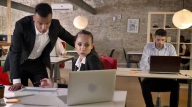 Genç meslektaşları grafik ofis, görüşüyorlar gülümseyerek, ağ teknolojileri, çalışma kavramı, iş kavramı, iletişim kavramı ile