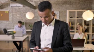 Genç afro Amerikalı işadamı tablet Office dokunarak, arkadaşları ağ teknolojileri, çalışma kavramı, iş kavramı, iletişim kavramı ile