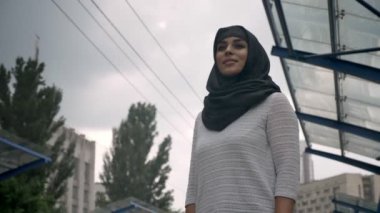 Hijab genç Müslüman kadın tren n Tren İstasyonu, yağmur, din kavramı, kentsel kavramı için bekliyor. Hava kavramı, alttan görünüm