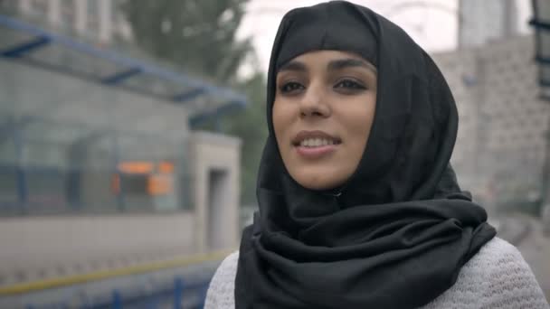 Wanita muslim bermimpi muda dalam hijab sedang menunggu untuk kereta api, hujan, konsep agama, konsep perkotaan. konsep cuaca — Stok Video