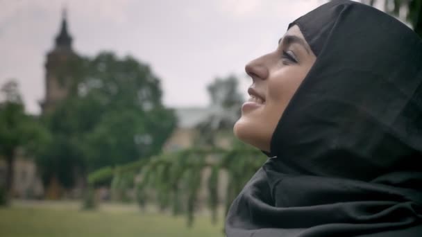 Gadis muslim muda yang cantik mengenakan jilbab sedang menonton di langit, menikmati cuaca, konsep religiuos — Stok Video