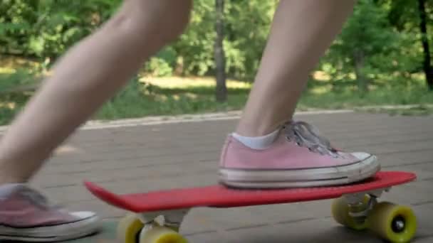 Weibliche Beine auf Skateboard im Park, asiatische weibliche Hipster auf Skate und mit Rucksack — Stockvideo