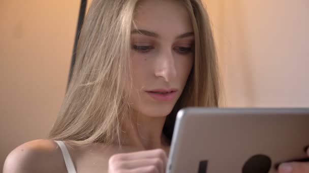 Portrait of young beautiful blonde women in lingerie using tablet and smiling, happy — Stock Video