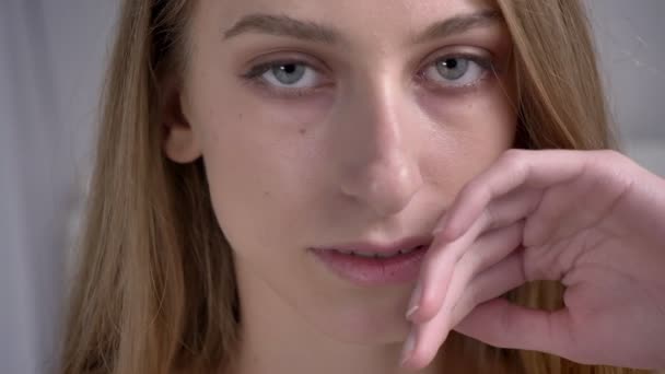 Πορτρέτο των νέων αρκετά γυναικών αγγίζει το πρόσωπό της και ψάχνει στην κάμερα, ελκυστικές και αυτοπεποίθηση — Αρχείο Βίντεο