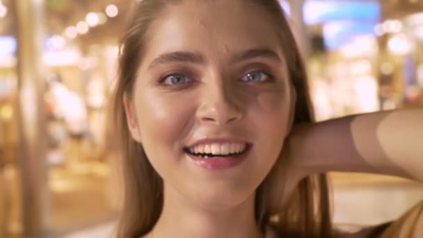 Aantrekkelijk meisje gaat winkelen in winkelcentrum, lachen, raakt haar, shopping concept, mode concept — Stockvideo