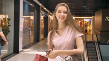 Çantalar, kameraya, kavram, alışveriş izlerken taşıyan genç çekici kızlar alışveriş merkezinde daimi kavramı moda