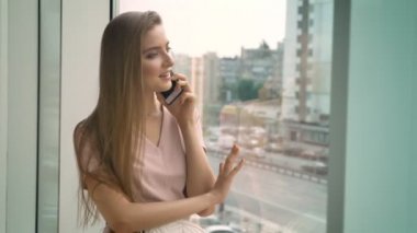 Genç güzel kız camda, gündüz, iletişim kavramı, kentsel kavram smartphone üzerinde konuşurken oturuyor