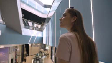 Genç çekici kız alışveriş merkezi, alışveriş kavramı, moda kavramı yürüyen merdiven üzerinde duruyor