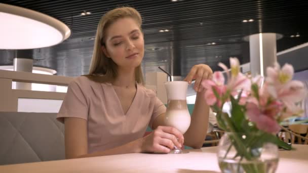 年轻漂亮的女孩坐在 rastaurant, 看着相机, 喝咖啡, 放松的概念 — 图库视频影像