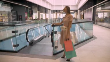 İzlerken kamera, dokunaklı saç, alışveriş kavramı, moda kavramı, çantalar, taşıyan genç çekici kızlar alışveriş merkezinde daimi kavramı flört