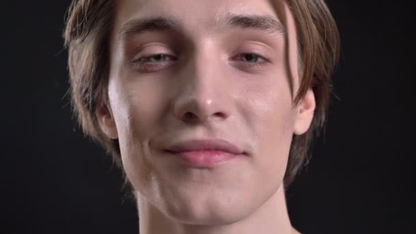 Portret van een jonge knappe man die lacht op camera, geïsoleerd op een witte achtergrond — Stockvideo