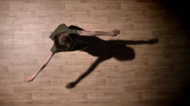 Genç kız silüeti dans, ahşap zemin, rahatlatıcı, bale kavramı, hareket kavramı, en iyi atış dönüyor