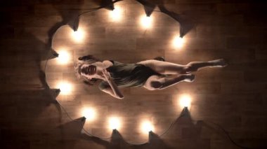 Genç kız balerin silueti olduğunu dans ve ahşap zemin döşeme, ışıklar, bale kavramı, hareket kavramı, en iyi atış