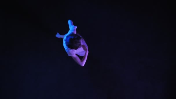 La silhouette della giovane ragazza sta ballando sul pavimento blu scuro, concetto di balletto, concetto di movimento, colpo in alto — Video Stock