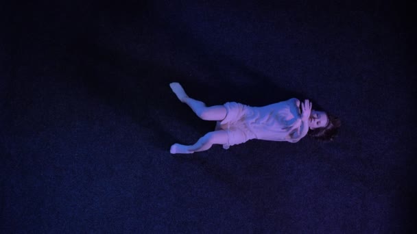 Σιλουέτα του νεαρό κορίτσι μπαλαρίνα χορεύει και τοποθέτηση σκούρο μπλε πάτωμα, μπαλέτο έννοια, έννοια κίνημα, κορυφαία πυροβόλησε — Αρχείο Βίντεο