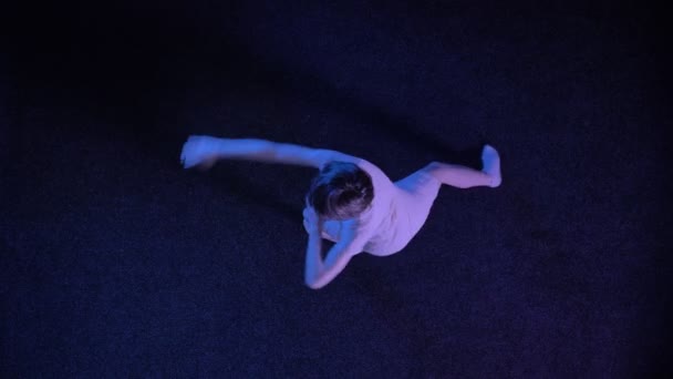 Silueta de niña está bailando, espinando en el suelo azul oscuro, concepto de ballet, concepto de movimiento, tiro superior — Vídeos de Stock