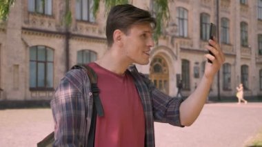 Genç yakışıklı adam vardır ihbar Smartphone, görüntülü sohbet, sallayarak yaz aylarında gündüz iletişim kavramı