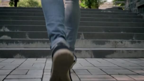 Силует молодого чоловіка біжить по сходах в парку вдень влітку, поспішаючи концепція — стокове відео