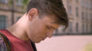 Yakışıklı delikanlı smartphone içinde gündüz yaz, kamera, iletişim kavramı, arka plan bulanık, izlerken izliyor