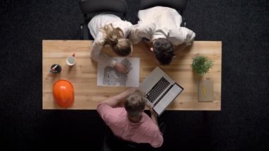 Üç işçi planı bina ve seyretmek laptop, ekip çalışması kavramı, office kavramı, iletişim kavramı tartışmak