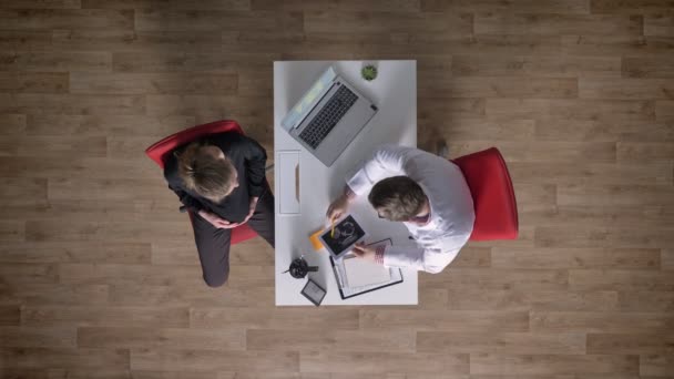 Dokter echografie te geven aan jonge zwangere vrouw, topshot, specialist adviseren toekomstige moeder, aan tafel zitten met laptop — Stockvideo