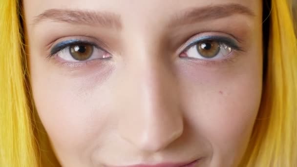 Nära porträtt av ögonen på kvinna med gula hår, öppnar ögonen, ovanlig person som stirrar på kamera, intensiv och koncentrerad — Stockvideo