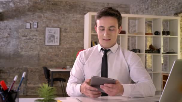 Joven hombre de negocios está trabajando con la tableta en la oficina, mostrando la pantalla verde, punto en él, concepto de negocio, concepto de comunicación — Vídeos de Stock