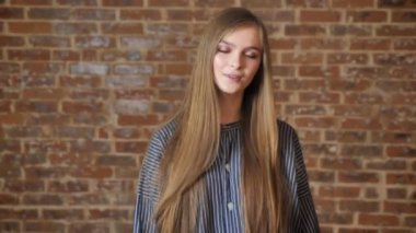 Uzun saçlı Genç kız saç dokunmadan gözleri kapalı, dans ediyor, müzik keyfi, arka plan tuğla