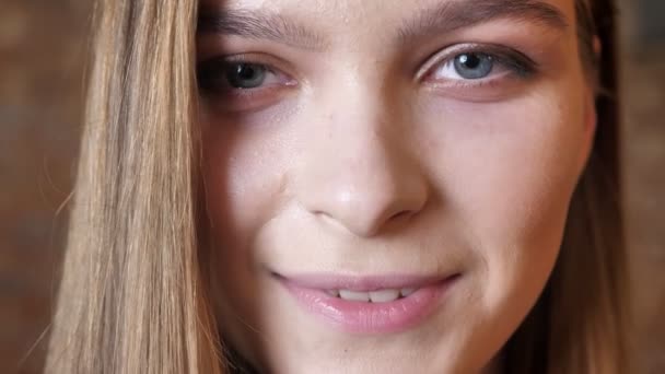Visage de jeune fille est souriant, regarder à la caméra, concept de rêve, fond flou — Video