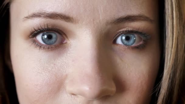 Los ojos de la joven chica atractiva está sonriendo, mirando a la cámara, fondo de ladrillo — Vídeos de Stock